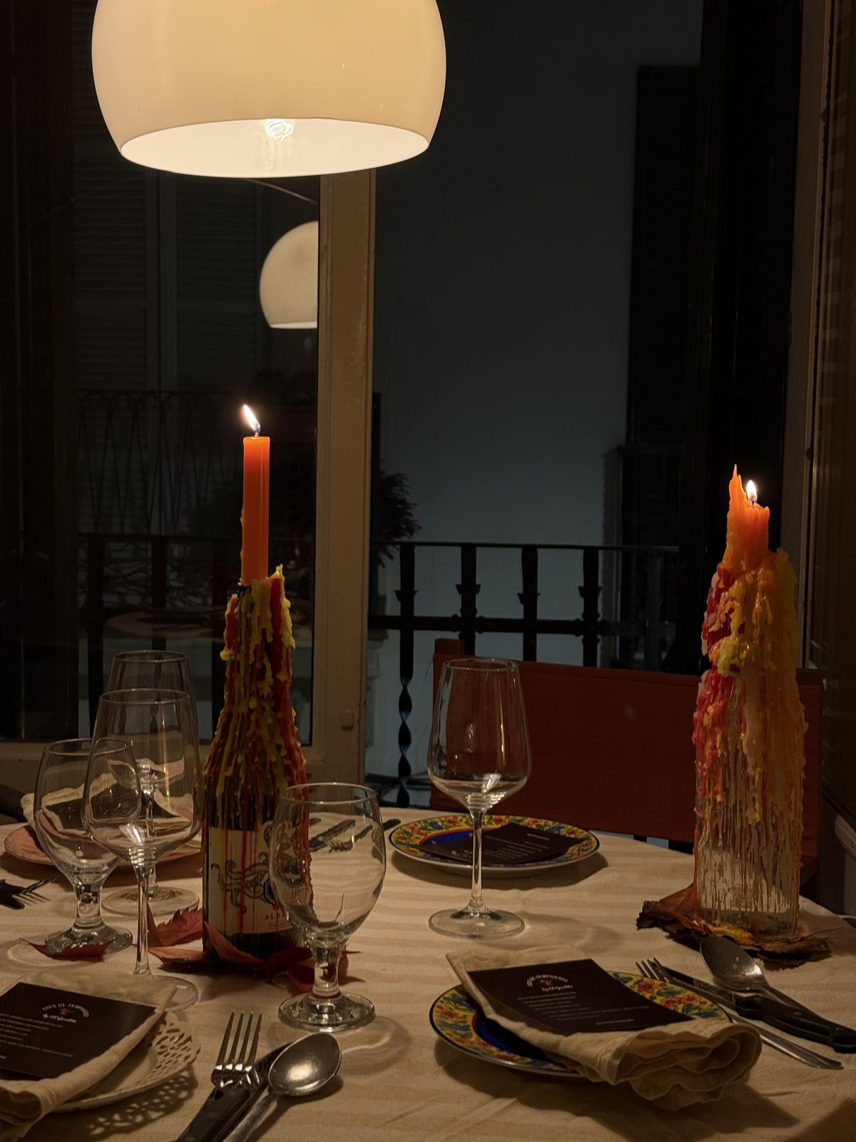 Mesa puesta con velas, copas y carta para una cena privada